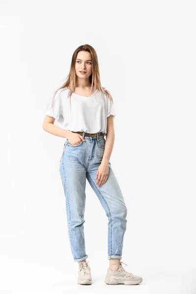 Jeune femme élégante en jeans sur fond blanc — Photo