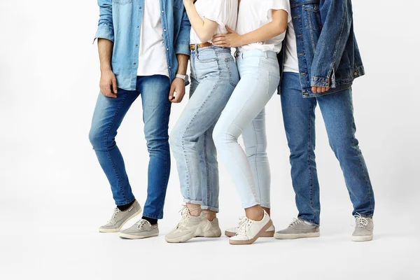 Jovens elegantes em jeans roupas em fundo branco — Fotografia de Stock