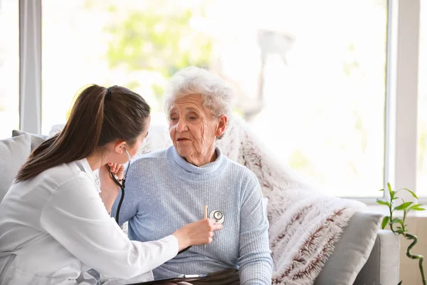 Doctor examining senior woman in nursing home