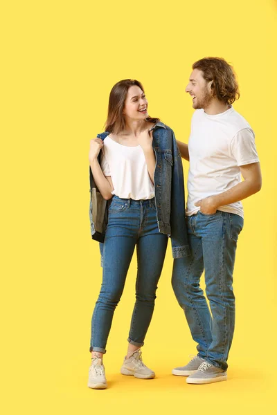 Elegante giovane coppia in jeans su sfondo colore — Foto Stock