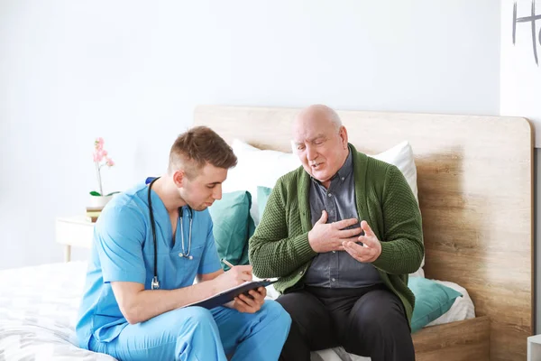 Medical worker with senior man in nursing home — Stock Photo, Image