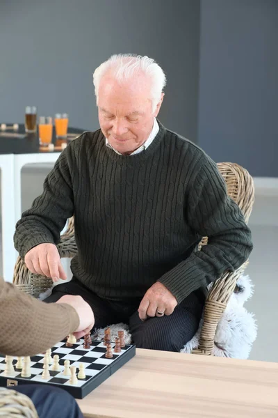 Старші чоловіки грають в шахи в будинку престарілих — стокове фото
