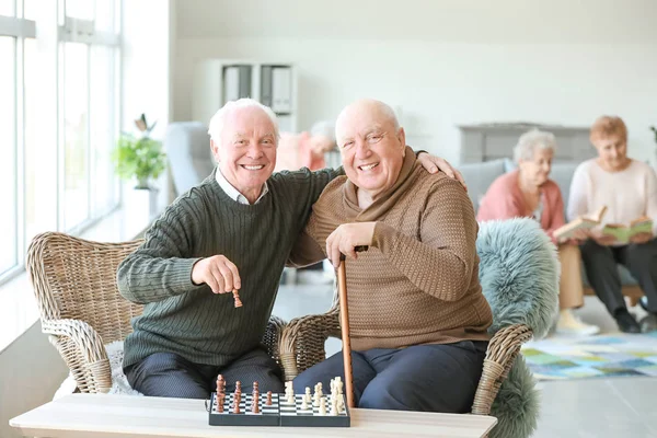 Uomini anziani che giocano a scacchi in casa di cura — Foto Stock