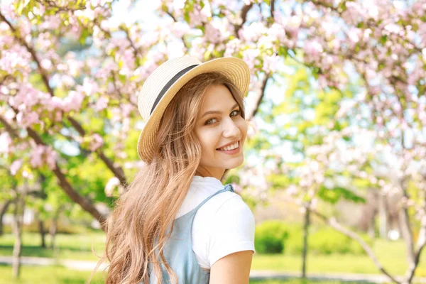 Beautiful young woman in park on spring day — Stock Photo, Image