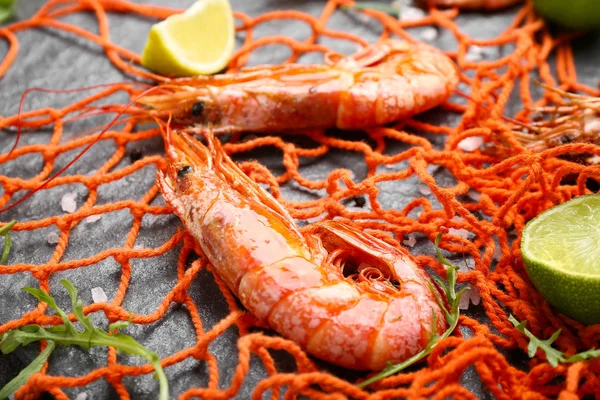 Tasty shrimps with mesh on slate plate, closeup — Stock Photo, Image