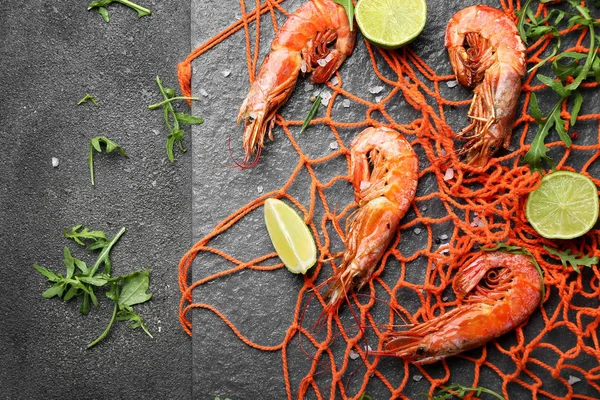 Tasty shrimps with mesh on slate plate — Stock Photo, Image