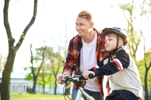 Padre enseñando a su hijo a andar en bicicleta al aire libre —  Fotos de Stock