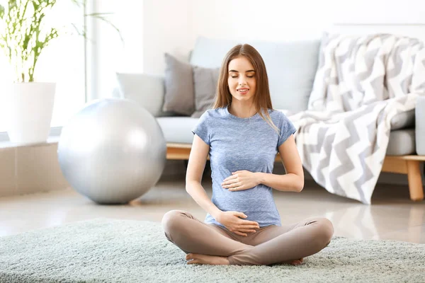 Beautiful pregnant woman meditating at home — Stock Photo, Image