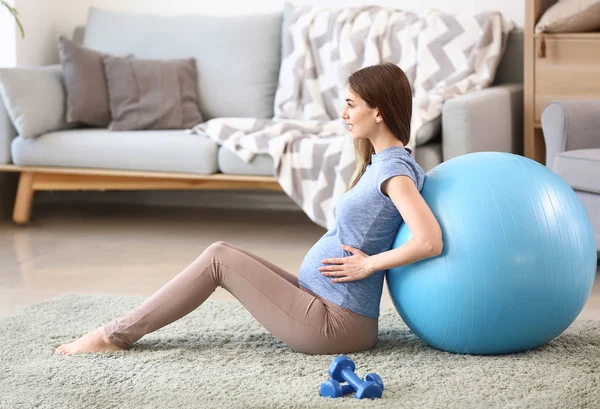 Красивая беременная женщина с фитболом в тренажерном зале — стоковое фото
