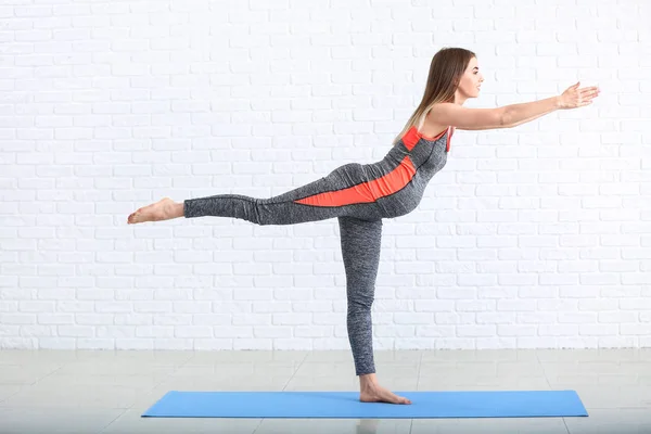 Mooie zwangere vrouw training in de buurt van witte bakstenen muur — Stockfoto