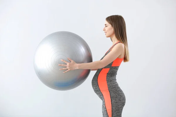 美丽的孕妇与灰色背景的健身球训练 — 图库照片