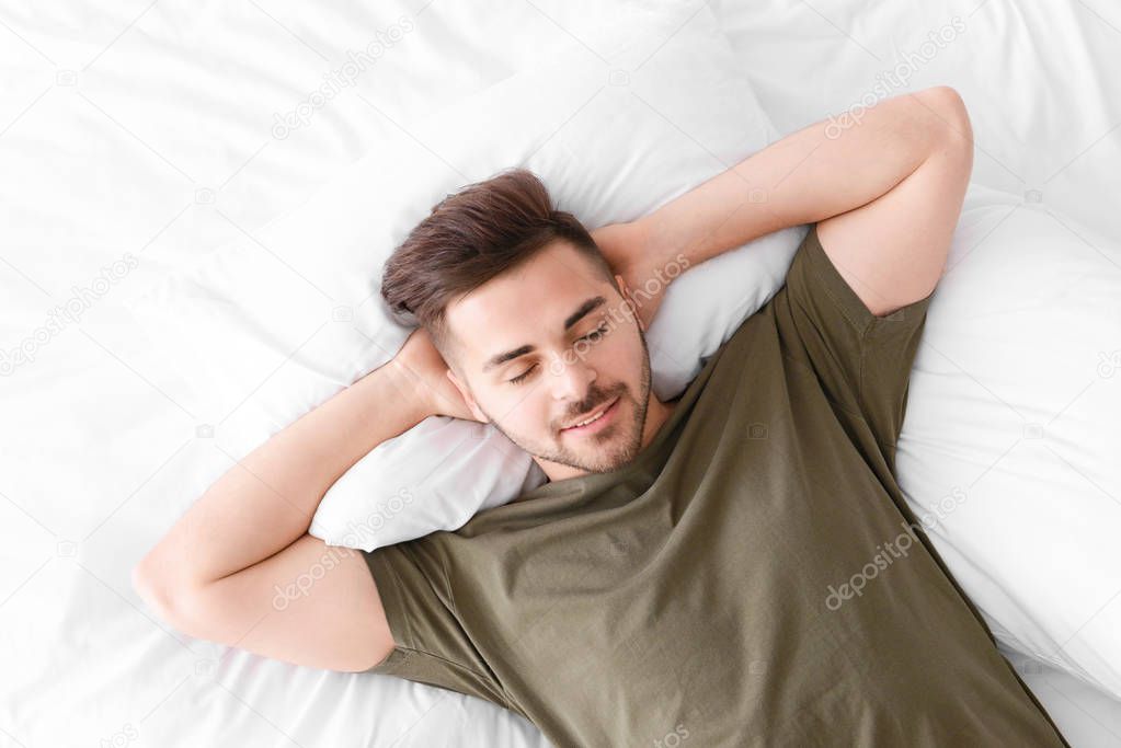 Handsome man sleeping in bed at home