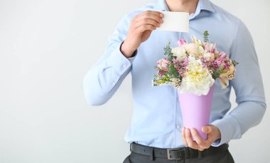 Güzel çiçekler ve ışık arka planda tebrik kartı buket ile yakışıklı adam