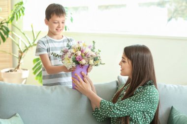 Küçük oğlu evde çiçek buketi ile annesini tebrik
