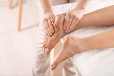 Spa salonunda vücut fırçası ile tedavi gören genç kadın