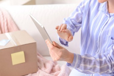Evde paket ve tablet bilgisayar ile genç kadın