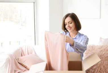 Genç kadın evde yeni satın alma ile parsel açılış