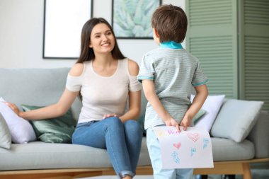 Küçük çocuk annesi evde arkasından için tebrik kartı gizleme