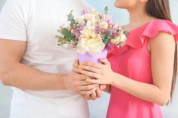 年轻夫妇与花束美丽的花在光的背景，特写 — 图库照片