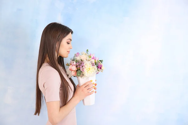 Beautiful young woman with bouquet of flowers on color background — Stock Photo, Image