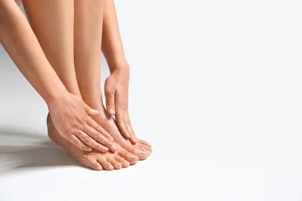 Beautiful young woman applying body scrub against white background — Stock Photo, Image