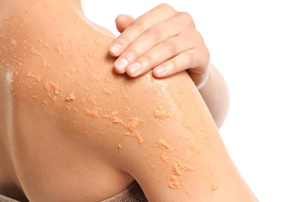 Hermosa mujer joven aplicando exfoliante corporal sobre fondo blanco, primer plano —  Fotos de Stock