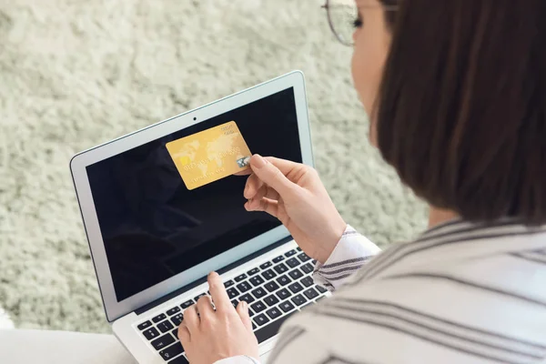 Młoda kobieta z kartą kredytową i laptopem zakupy online w domu — Zdjęcie stockowe