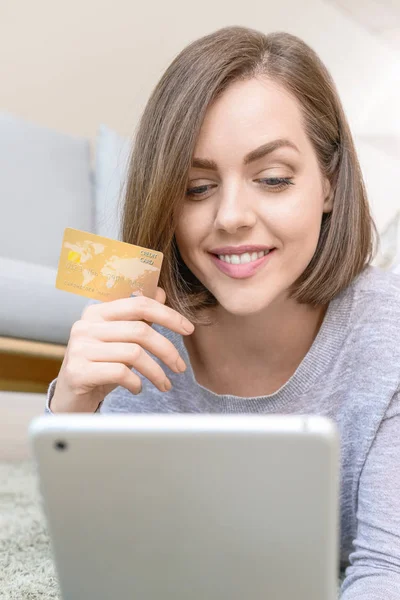 Jeune femme avec carte de crédit et tablette achats en ligne à la maison — Photo