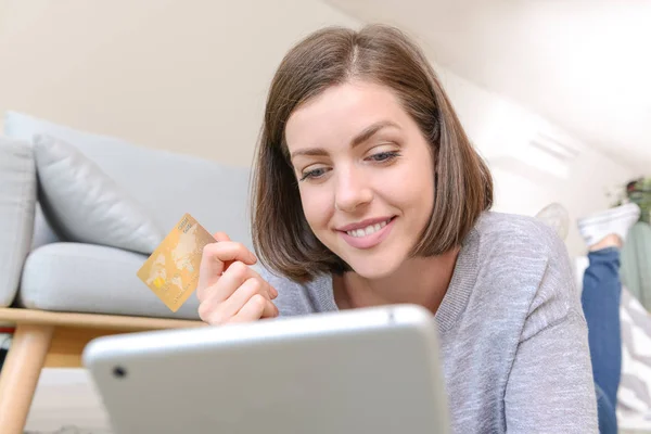 Jeune femme avec carte de crédit et tablette achats en ligne à la maison — Photo