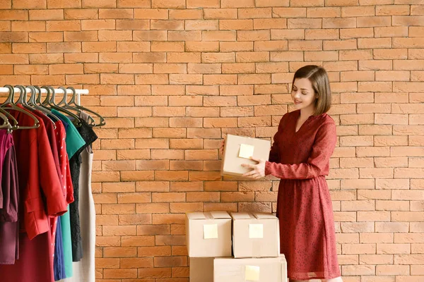 Propietaria femenina de tienda de ropa preparando pedidos para clientes — Foto de Stock