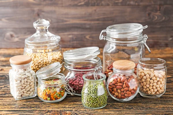 Pots avec assortiment de légumineuses sur table en bois — Photo