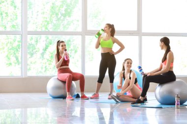 Spor salonunda fitballs içme şişesi ile genç sportif kadınlar