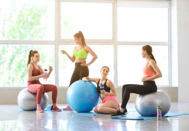 Spor salonunda fitballs içme şişesi ile genç sportif kadınlar