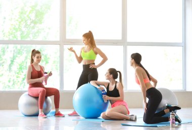 Spor salonunda fitballs içme şişesi ile genç sportif kadınlar