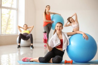 Spor salonunda fitball içme suyu ile genç sportif kadın