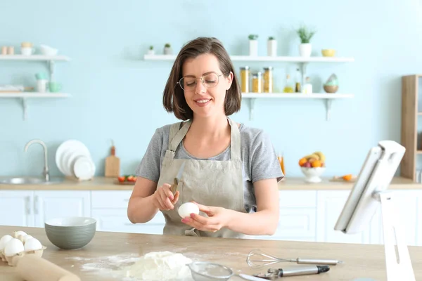 Beautiful young woman cooking pastry in kitchen — Stock Photo, Image