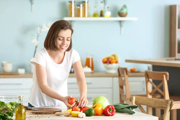 Mujer joven haciendo ensalada en la cocina —  Fotos de Stock