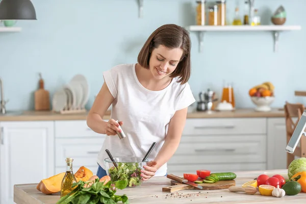 Mujer joven haciendo ensalada fresca en la cocina —  Fotos de Stock