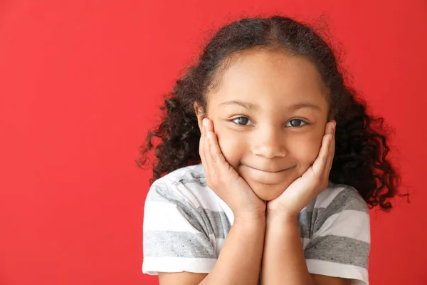 Portrait of adorable little African-American girl on color background — Stock Photo, Image