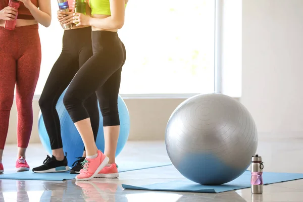 Young sporty women with fitballs drinking bottle in gym — Stock Photo, Image