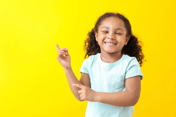 Portrait de heureuse petite fille afro-américaine sur fond de couleur — Photo