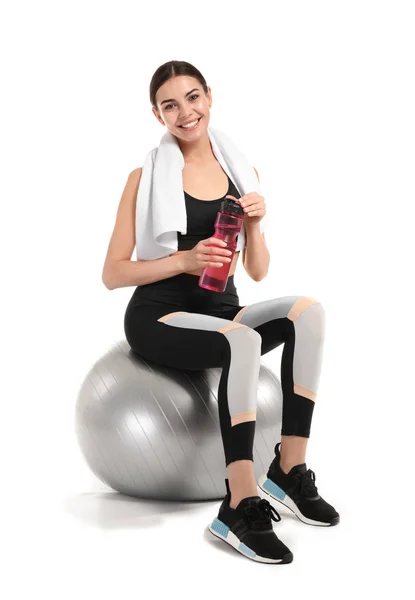 年轻的运动女人与健身球和瓶水在白色背景 — 图库照片