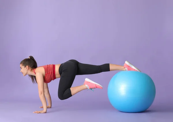 Genç sportif kadın renkli arka planda a ile egzersizleri yapıyor — Stok fotoğraf