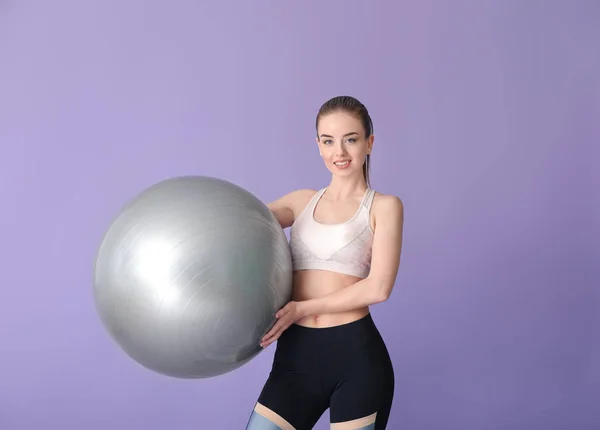 年轻的运动女人与健身球的颜色背景 — 图库照片