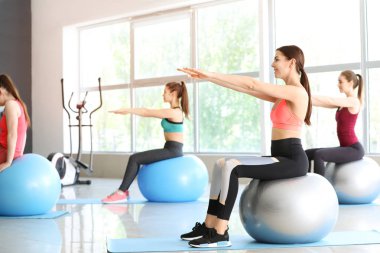 Spor salonunda fitballs ile egzersiz yapan genç sportif kadınlar