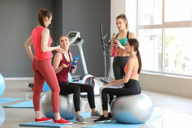 Spor salonunda fitballs içme şişesi ile genç sportif kadınlar