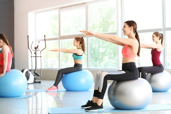 Junge sportliche Frauen turnen mit Fitnessbällen im Fitnessstudio — Stockfoto
