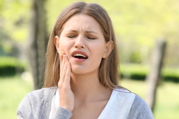 Young woman suffering from toothache outdoors — Stock Photo, Image