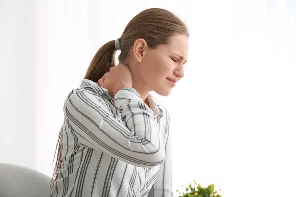 Молода жінка страждає від болю в шиї вдома — стокове фото