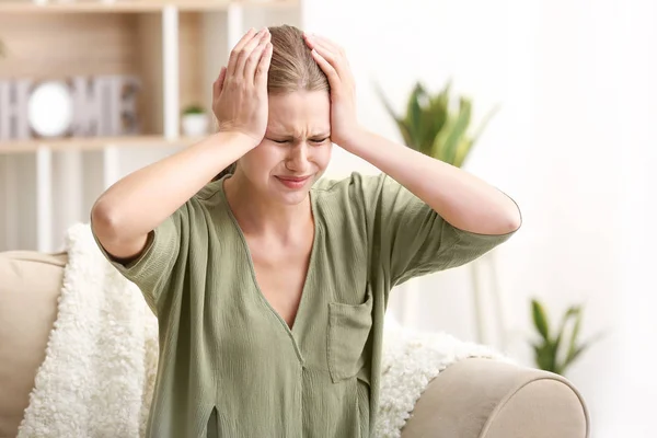 Mujer joven que sufre de dolor de cabeza en casa —  Fotos de Stock